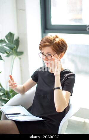 Smiling therapist taking notes and talking about something Stock Photo