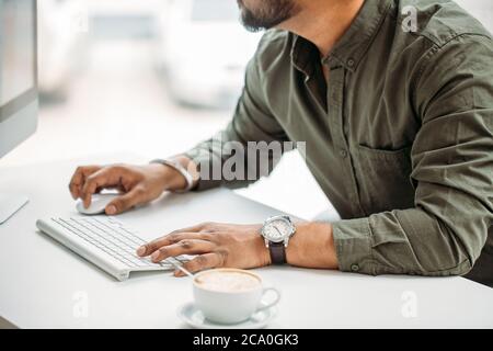young indian man working at computer from modern bright office Stock Photo