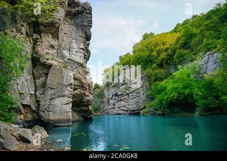 the river flows through a canyon with large stones and rocks Stock Photo