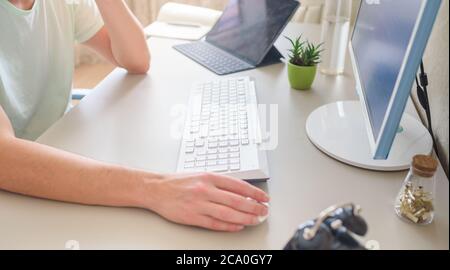 the developer works at the computer, typing, uses the mouse. Selective focus Stock Photo