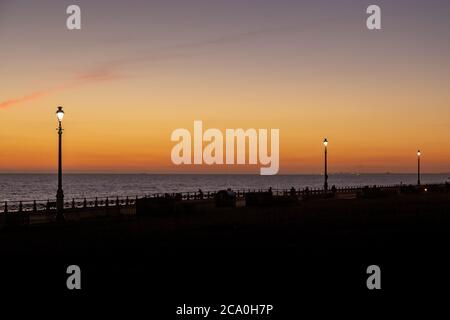 Street lamps on Brighton seafront at sunset Stock Photo