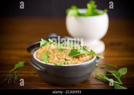 boiled bulgur groats with vegetables and herbs in a ceramic bowl Stock Photo