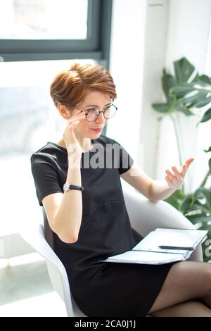 Smiling therapist taking notes and talking about something Stock Photo