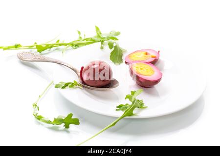 marinated chicken eggs in beetroot marinade in a plate isolated on white background Stock Photo