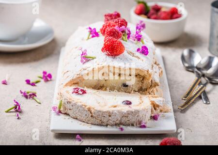 Meringue roll cake with cream and raspberries. Roulade, summer dessert, closeup. Stock Photo