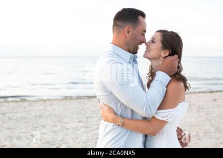 romantic couple embracing and looking at each other smiling Stock Photo