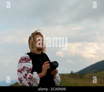 girl with a camera on the background of a mountain peak in Ukrainian embroidery Stock Photo