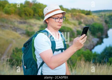 the guy looks at the map navigation in the phone while traveling Stock Photo