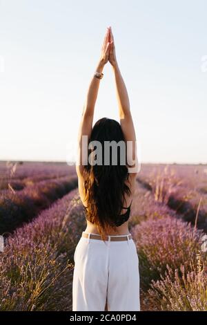 Brunette woman on her back stretching her in lavender field Stock Photo