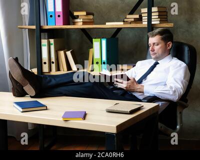 Confident young businessman in the office makes notes in a notebook. Stock Photo