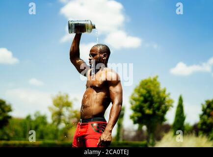 young athlete cooling off with water after doing sports Stock Photo