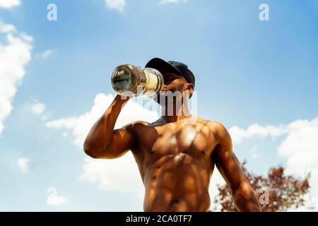 young athlete hydrating himself with water after doing sports Stock Photo