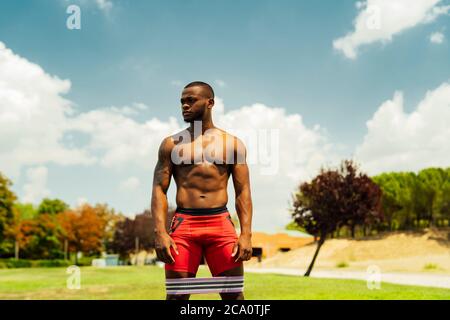 young athlete doing leg exercises with rubber bands Stock Photo