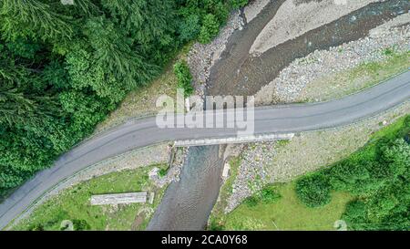 Automobile bridge over the river on the background of the forest in the mountains. Stock Photo