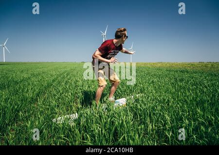 ODESSA, UKRAINE - MAY, 20 2015: Young hipster man surfer is kidding and surfing in the green field Stock Photo