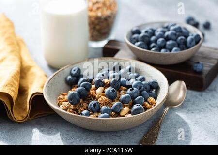 Bowl of granola with blueberries and bottle of milk. Healthy breakfast food Stock Photo