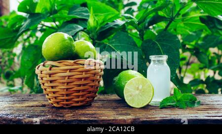 a basket full of lemons, half cut lemon and lemon juice in a glass jar closeup Stock Photo