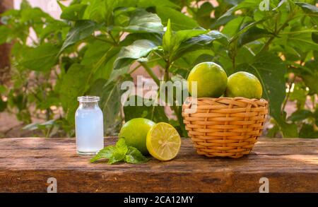 a basket full of lemons, half cut lemon and lemon juice in a glass jar closeup Stock Photo