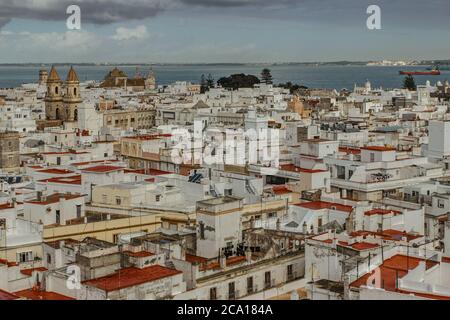 Aerial dramatic panoramic view of the old city, rooftops and seashore in cloudy day from tower Tavira in Cadiz, Andalusia, Spain.European cityscape.Be Stock Photo