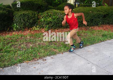 Young black boy running outside Stock Photo
