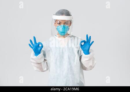 Covid-19, coronavirus disease, healthcare workers concept. Confident and serious asian female doctor, lab technician in personal protective equipment Stock Photo