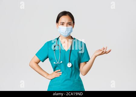 Confused asian woman in medical face mask, looking clueless, puzzled ...