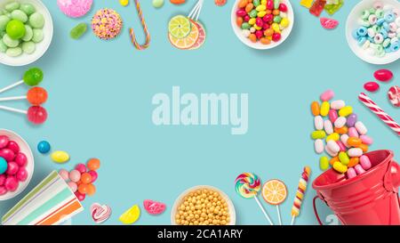 Lollipops and candies. Colorful sweets, festive decoration. Colorful candies on alight blue background, top view with copy space for message or greeti Stock Photo