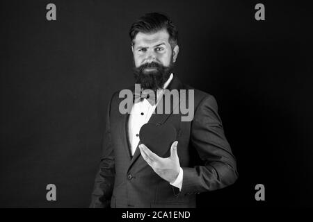 Trust me. Happy valentines day. Tuxedo man hold red heart. Love concept. Passionate mature lover hipster in formal suit. Businessman with bow tie. Romantic greeting. Fall in love. Celebrate love. Stock Photo