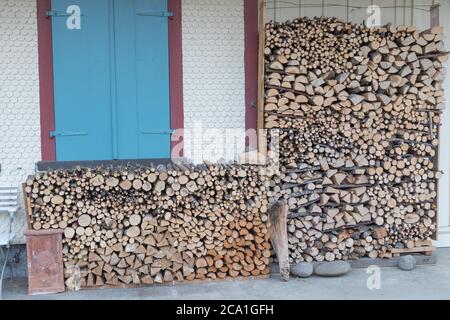 firewood stock in front of wooden house Stock Photo