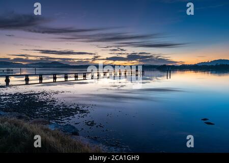 Sunrise waterscape with wharf, high cloud and reflections at Woy Woy Waterfront on the Central Coast, NSW, Australia. Stock Photo