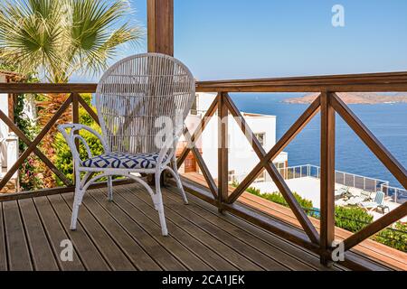 wooden terrace of holiday villa or hotel with vintage chair and sea view Stock Photo