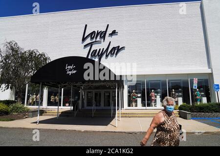 New York, USA. 3rd Aug, 2020. A woman walks past a Lord & Taylor store in Long Island, New York, the United States, on Aug. 3, 2020. Lord & Taylor, one of America's oldest department stores, filed for bankruptcy protection on Sunday, joining a growing list of stores slammed by the COVID-19 pandemic. Credit: Wang Ying/Xinhua/Alamy Live News Stock Photo