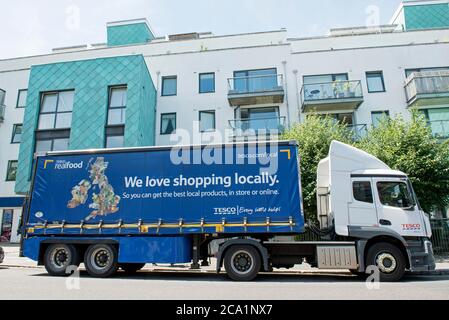 Tesco large, articulated delivery lorry or van parked outside shop in Drayton Park, London Borough of Islington Stock Photo