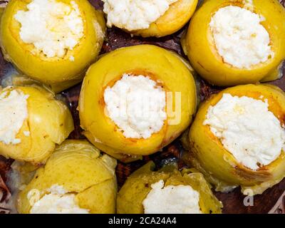 Baked apples stuffed with cottage cheese on a plate. Stock Photo