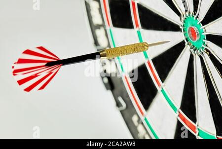 Darts on a white background. 1 dart flies directly to the center of the target. Business center goal concept. Stock Photo