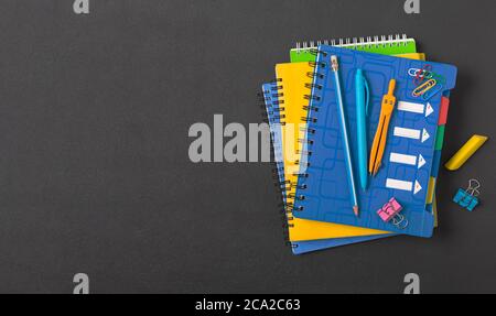 School concept, notebooks and pens on a black school board. top view Stock Photo