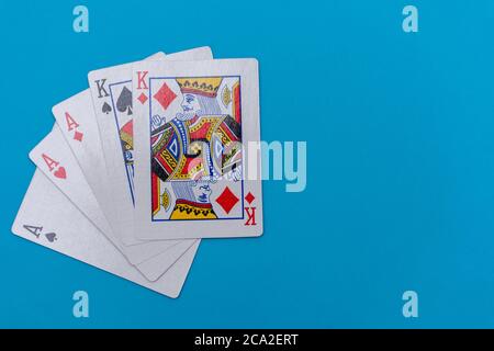 Full house hand of cards on bright blue flat lay in a game of texas holdem poker gambling at a casino concept. Stock Photo
