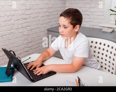 Caucasian boy using tablet pc computer studying homework at home Stock Photo