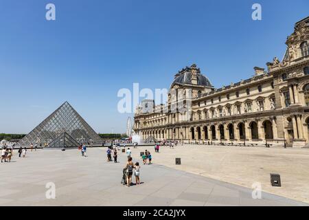 Paris, France - June 27, 2019: View of pyramid and fountain at courtyard of Louvre Museum. Louvre Museum is one of the largest and most visited Stock Photo