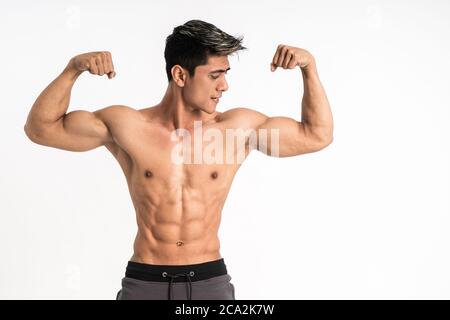 half body image of young man showing muscular biceps stand facing forward with copyspace on isolated background Stock Photo