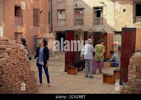 Bhaktapur citizens checking wardrobe closets between piles of bricks. Bhaktapur, Nepal, one year after the 2015 Nepal earthquakes. Stock Photo