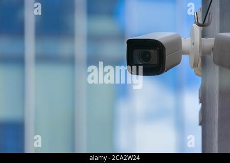 Modern CCTV security camera installed on building wall in city. Concept of surveillance and monitoring. Stock Photo