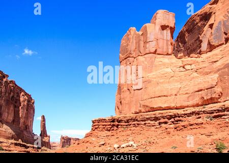 Desert rock formations under bright blue sky with wind blown clouds ...