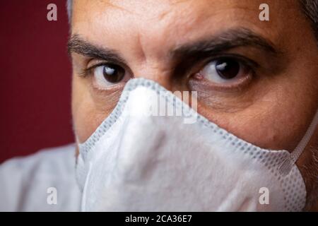 Closeup of man with a protective medical mask waits for the end of the emergency quarantine covid-19.