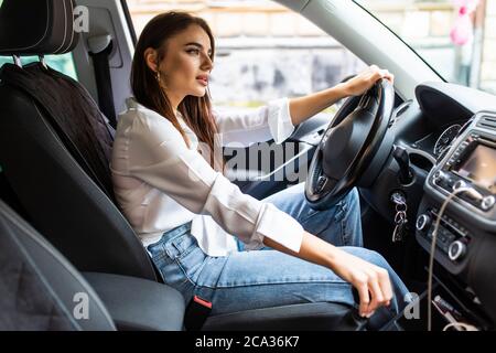 Photo of young woman choosing a new car in automobile center Stock Photo