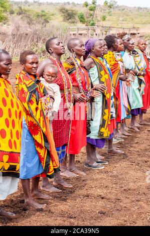 Maasai women wearing traditional attire in a traditional dance, in a ...