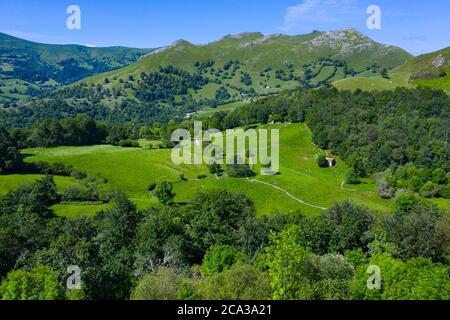 Spring landscape of mountains, meadows of mowing and cabins pasiegas in the Miera Valley, Cantabria, Spain, Europe.