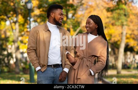 Portrait of black millennial couple walking together in autumn park Stock Photo