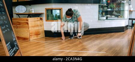 Coffee shop worker putting floor marks Stock Photo