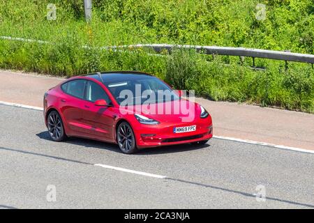 2019 Red Tesla Model 3 Performance AWD Vehicular traffic moving vehicles, cars driving vehicle on UK roads, motors, motoring on the M6 motorway highway network. Stock Photo